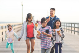 family walking down boardwalk with icecream