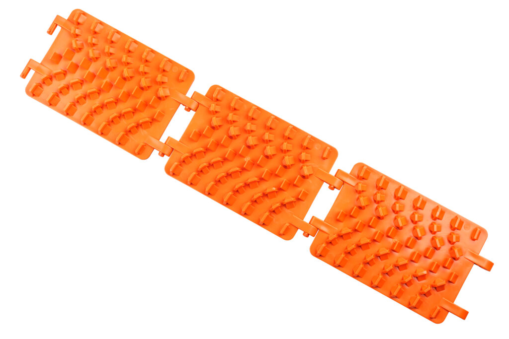 orange plastic foldable emergency traction pads isolated on white background